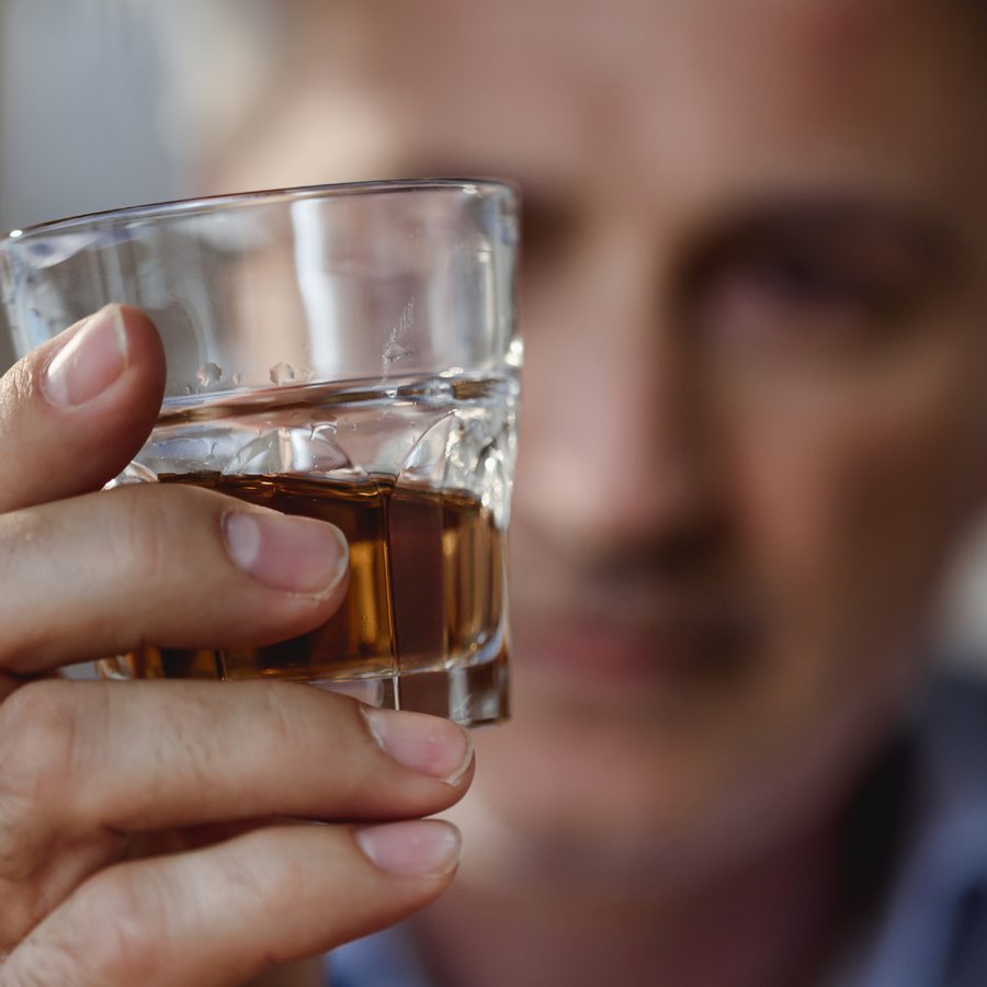 Dłoń trzymająca szklankę alkoholu
